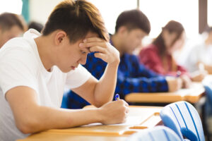 college students taking an exam in class